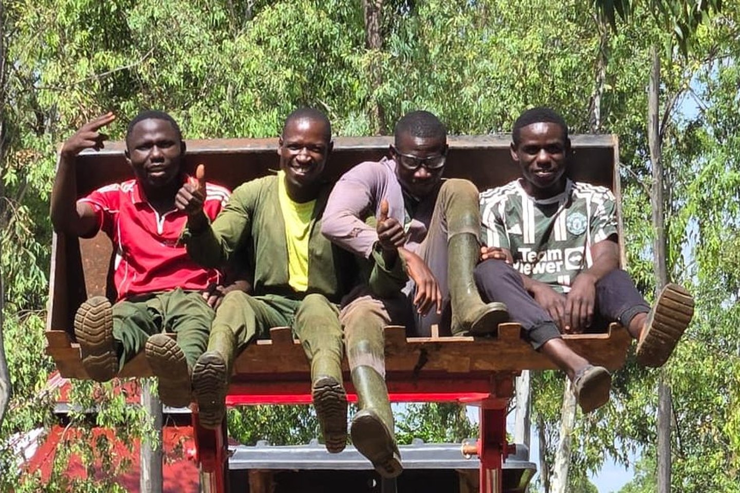 Four members of the New Life Farm team on the tractor loader