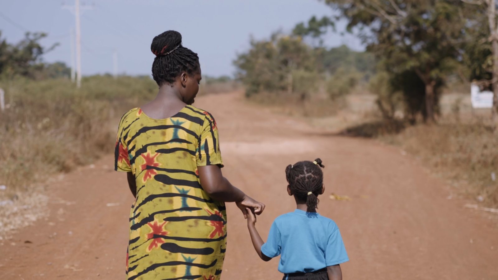 A mother and daughter walking a road near the New Life campus in Bulesa, Uganda