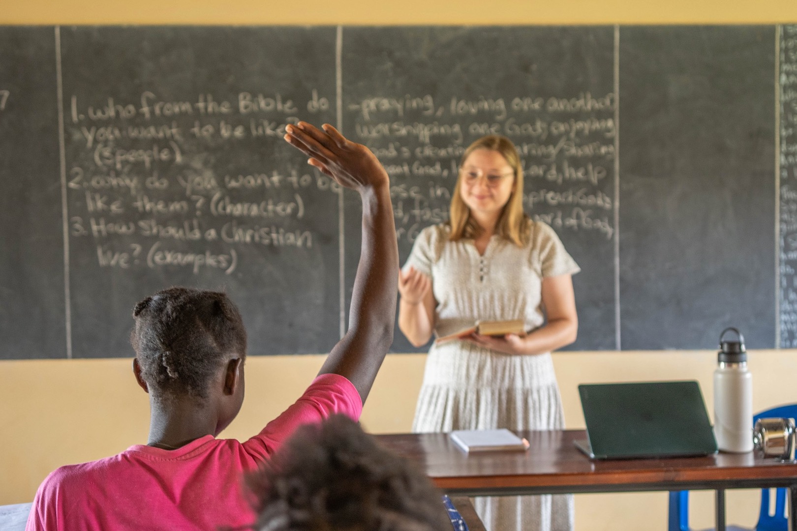 Katherine%20blurred%20with%20student%20raising%20hand%20in%20class